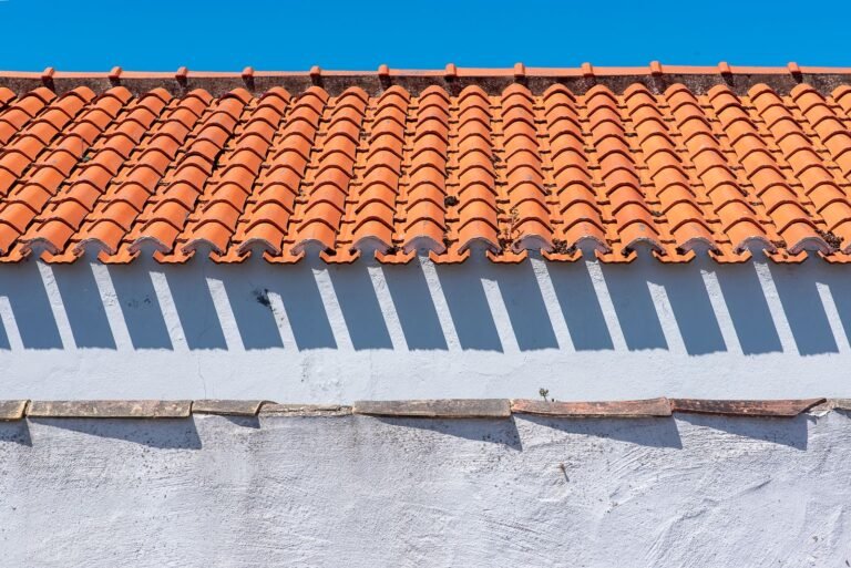Couverture toiture en tuiles canal terre cuite sur un mur blanc